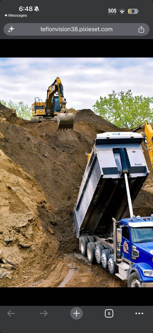 CAT excavator loading a raised tri-axle dump truck during site production